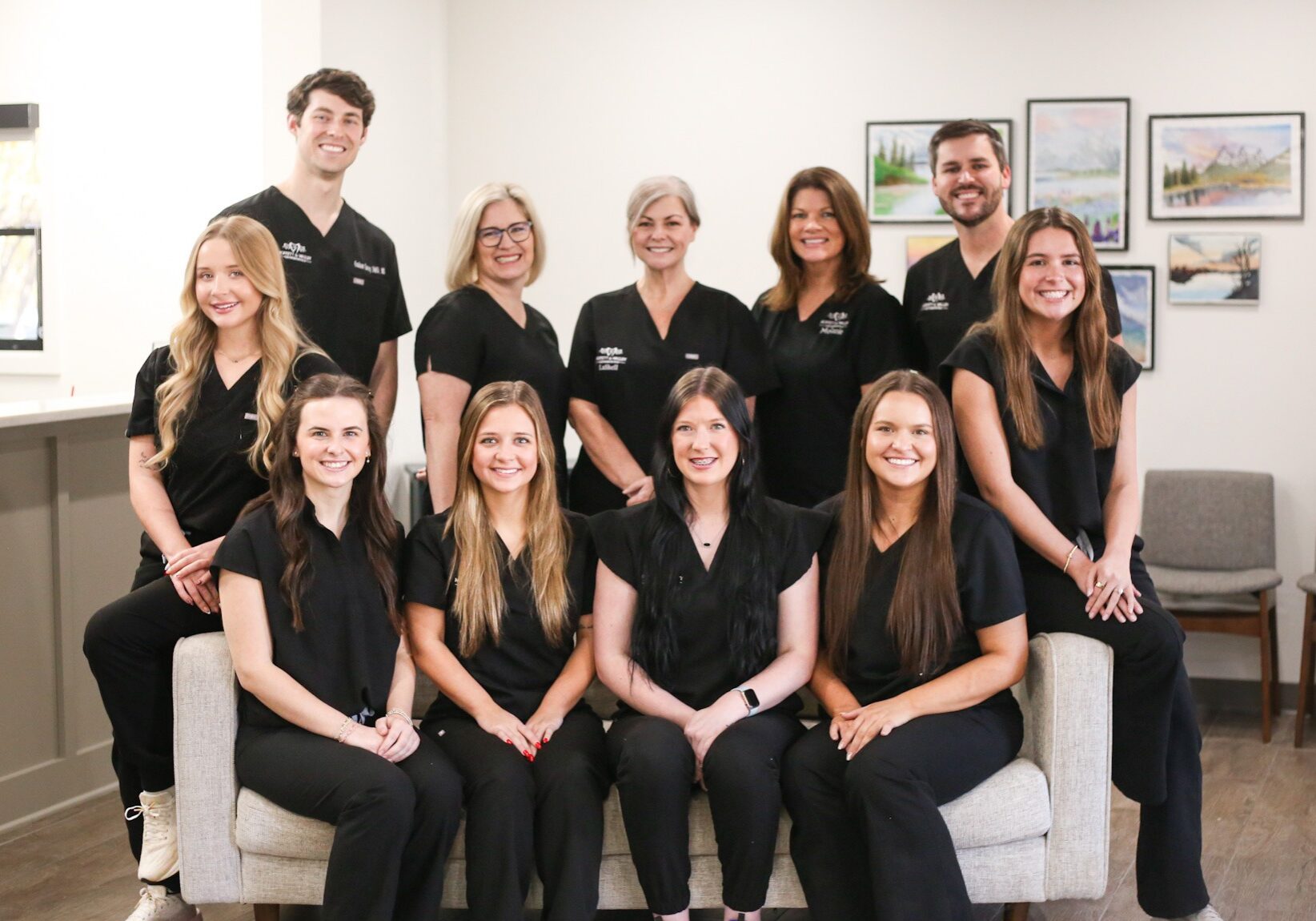 IMG_8024 Orthodontic team at Moffett & Walley Orthodontics smiling together in black scrubs, showcasing their friendly atmosphere and commitment to patient care.